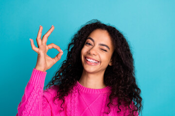 Wall Mural - Portrait of nice young girl eye wink show okey wear pink pullover isolated on turquoise color background