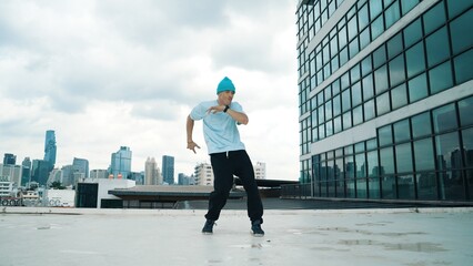 Wall Mural - Stylish caucasian dancing man performing break dance at skyscraper. Portrait image of young happy man practicing street dance performance choreographer in modern urban city. Paris style. Hiphop.