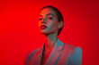 © Blockbits - Bold Woman in Light Gray Suit with Solid Neon Red Background Trendsetting Portrait