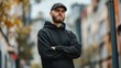 © Khalil - City portrait of handsome hipster guy with beard wearing black blank hoodie or sweatshirt and hat with space for your logo or design. Mockup for print