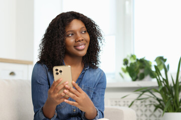 Wall Mural - Beautiful woman with mobile phone at home