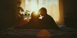 © Murda - Silhouetted couple on a bed with sunlight.