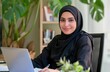 © Diana - A young woman in a black hijab working on her laptop in a cozy, well-lit home office with plants and books in the background