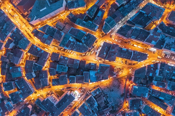 Aerial photo of an old neighborhood of city of Istanbul at night brightly lit featuring intricate street patterns and illuminated streets between historic buildings.