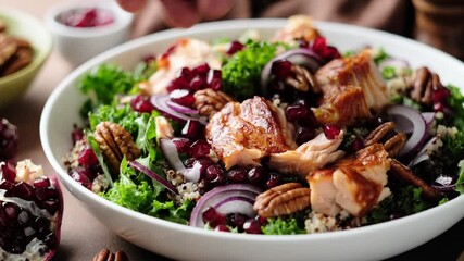 Wall Mural - Salmon salad bowl. Superfood salad with grilled salmon, kale, quinoa, pecan nuts, red onion and pomegranate, close-up. Stock video footage 4k