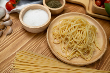 Health food's recipe ingredients of special menu homemade cooking raw spaghetti with tomato sauce and basil of macro photo shooting placing elements on preparing wooden blurred background. Postulate.