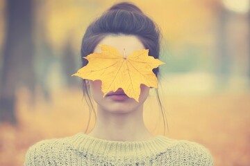 Wall Mural - On the background of a fall nature landscape, a beautiful autumn woman poses with autumn leaves