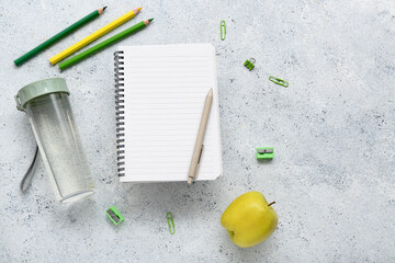 Wall Mural - Blank notebook with stationery and bottle of water on grunge white background