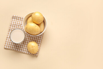 Canvas Print - Glass of tasty potato milk and fresh vegetables on beige background