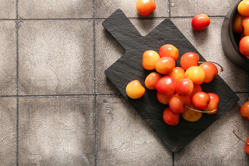 Canvas Print - Board with sweet yellow cherries on grey tile table