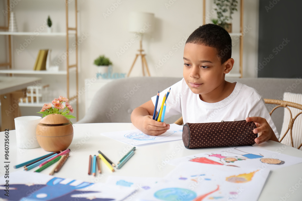Little African-American boy with pencil case at home