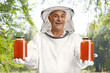 © Ljupco Smokovski - Happy male bee keeper in a uniform holding honey jars