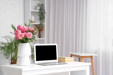 Canvas Print - Vase of beautiful pink dahlias with books and laptop on table in living room