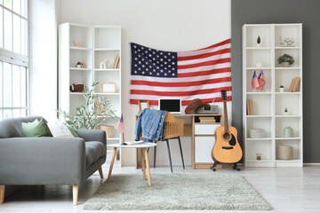 Wall Mural - Interior of living room with USA flag, grey sofa and comfortable workspace