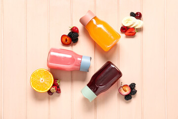 Poster - Sports bottles of fresh juice with different fruits on pink wooden background