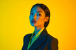 © Blockbits - Modern Woman in Dark Gray Suit with Neon Yellow Highlights, Posed Against a Solid Background for a Classy Fashion Lifestyle Portrait