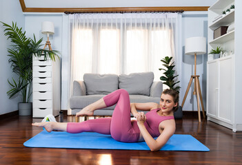 Wall Mural - Athletic and sporty woman doing crunch on fitness mat during home body workout exercise session for fit physique and healthy sport lifestyle at home. Gaiety home exercise workout training concept.