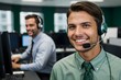 © Peidrow - Green dressed brown young man with a headset smiling, working as a call center operator in a busy office. Bussineswoman, representative, operator, assists with customer support and communication
