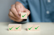 © Ei - Checklist survey concept. Man hand holding wooden cube with checklist icon. Survey checklist, assessment, quality control.