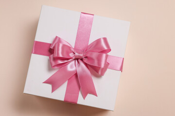 Canvas Print - Gift box with bow on beige background, top view