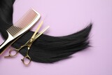 Black hair strand, comb and professional scissors on violet background, top view