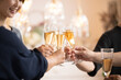 © kapinon - Image of toasting with champagne and wine glasses Close-up of hands without face