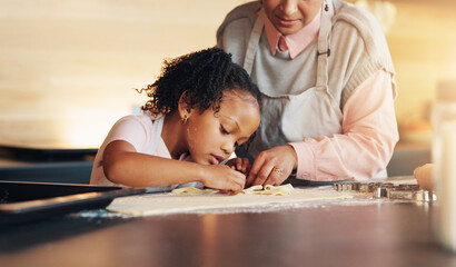 Poster - Grandparent, little girl and baking with cookie cutter on table in kitchen for learning, teaching or making dough at home. Grandma, child or junior baker with shapes for dessert or recipe at house