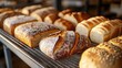 © Nottenaj - 3. A warm scene of freshly baked artisan loaves cooling on a wire rack, with different shapes and sizes, the light highlighting the crisp crusts and texture of each loaf