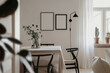 © Roman - Mockup of two empty vertical din A ratio blanks in black frame. Scandinavian style white background, dinning table and chairs, plants. Mock up poster frame in minimalist dinning room, kitchen interior