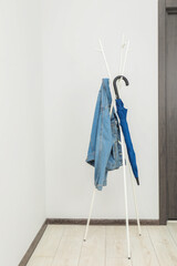 Wall Mural - Blue umbrella and denim jacket on clothing rack in hallway