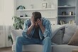 © Svetlana - Desperate moment of a lonely man crying on his couch at home, overwhelmed by anxiety and heartache after a tough day
