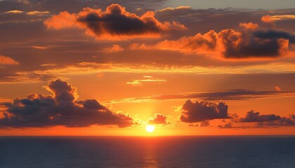 Wall Mural - Stunning sunset painting the ocean in vibrant orange hues with wispy clouds adorning the sky