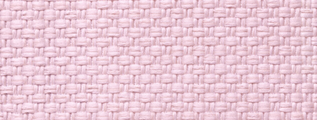 Texture light pink background from woven textile material with wicker pattern, macro. Vintage rose fabric cloth