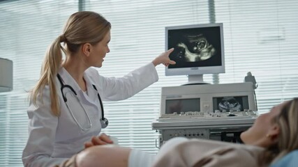 Wall Mural - Gynecologist performing sonogram examination closeup. Happy doctor showing baby