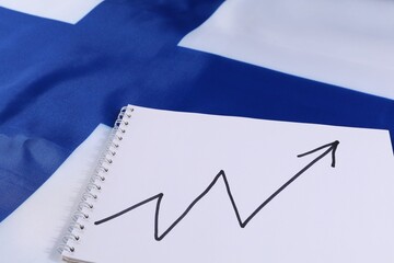 Chart showing growth trend on a notepad beside the Finnish flag