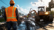 © Maksym - View from the back of a road worker directing traffic around a road repair site, with machinery and workers visible ahead.