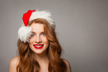 Happy Christmas woman in Santa hat with make-up and cute positive smile looking at camera, fashion portrait