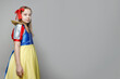 © millaf - Little girl theater actress in SnowWhite costume standing against white studio wall banner background with copy space