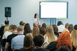© Anton Gvozdikov - Attentive audience seated at a business seminar, listening to a presenter in a conference room.