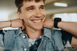 © Maskot - Happy young man with tattooed arm adjusting collar of jacket
