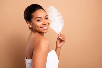 Poster - Photo of lovely pretty girl hold soft feather open shoulders isolated on beige pastel color background