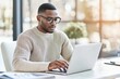 © Mark - A concentrated African-American man in smart casual wear focuses on a laptop's screen as he works or studies. African-American man in glasses focuses on the screen.