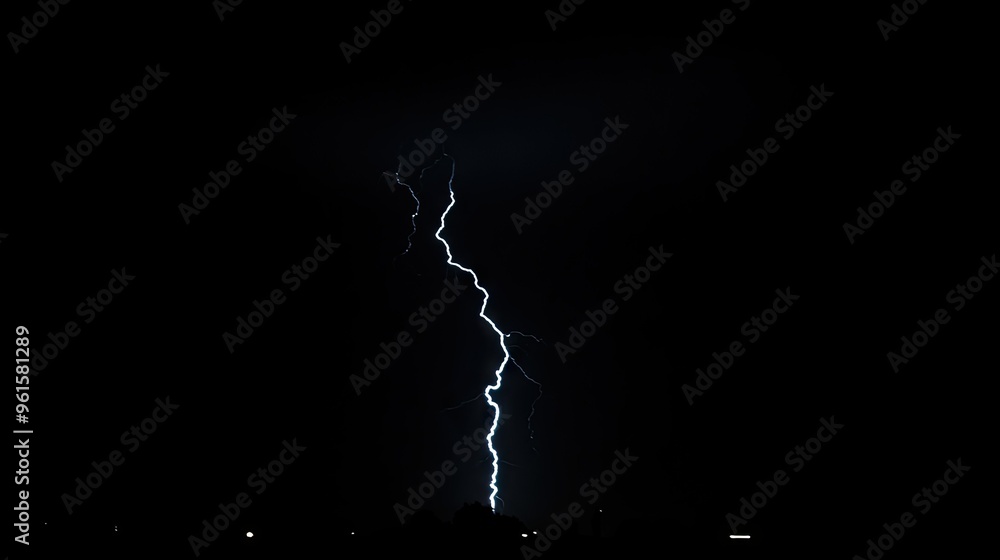 A single, intense lightning bolt striking down from the night sky ...
