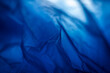 © Taigi - Extreme close up of blue empty plastic bag background. The plastic surface is wrinkly and tattered making abstract pattern. Selective focus, shallow depth of field.