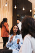 © Maskot - Young female entrepreneur discussing business strategy with delegate at convention center