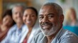 © YURY YUTY - Elderly man smiling, others blurred in the background, diverse group setting.