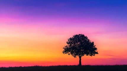 Wall Mural - A silhouette of a single tree against a colorful dusk sky, with the fading light creating a gradient of purples, oranges, and blues.