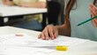 © kinomaster - High school teenagers in classroom, close up shot girl writing math exam, solving task on paper sheet. Modern education concept.