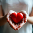 © 3r1k_ai - woman is holding a red heart. Concept for charity, health insurance, love, international cardiology day