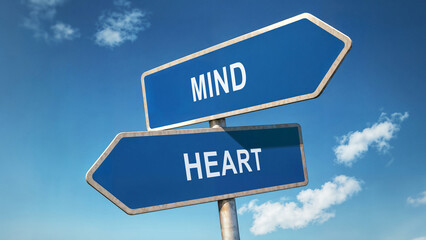 Two directional road signs with mind and heart options, symbolic crossroads under a clear blue sky, decision-making concept, choosing between logic and emotion represented by signpost choice